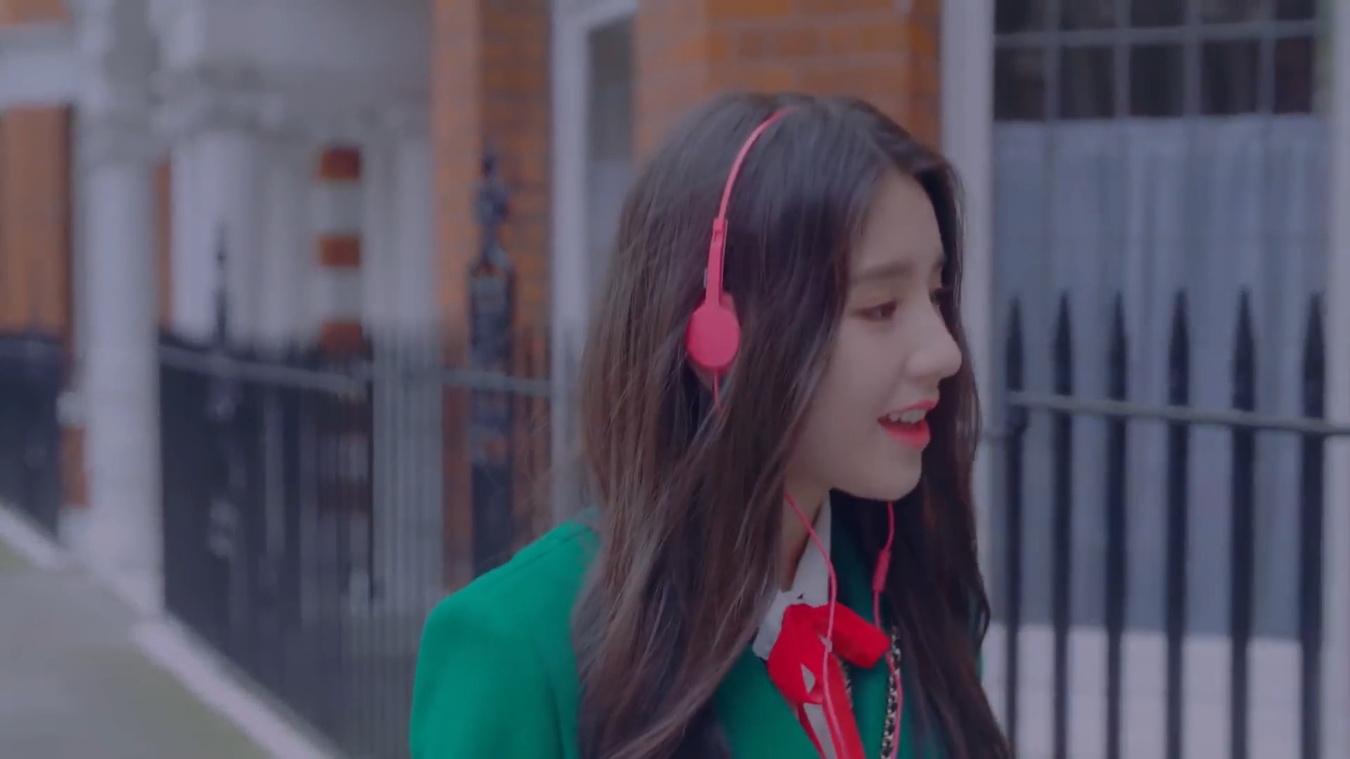 Heejin wearing pink headphones.